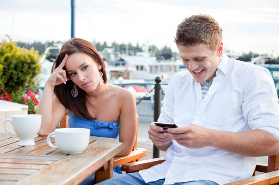 man-texting-while-on-date